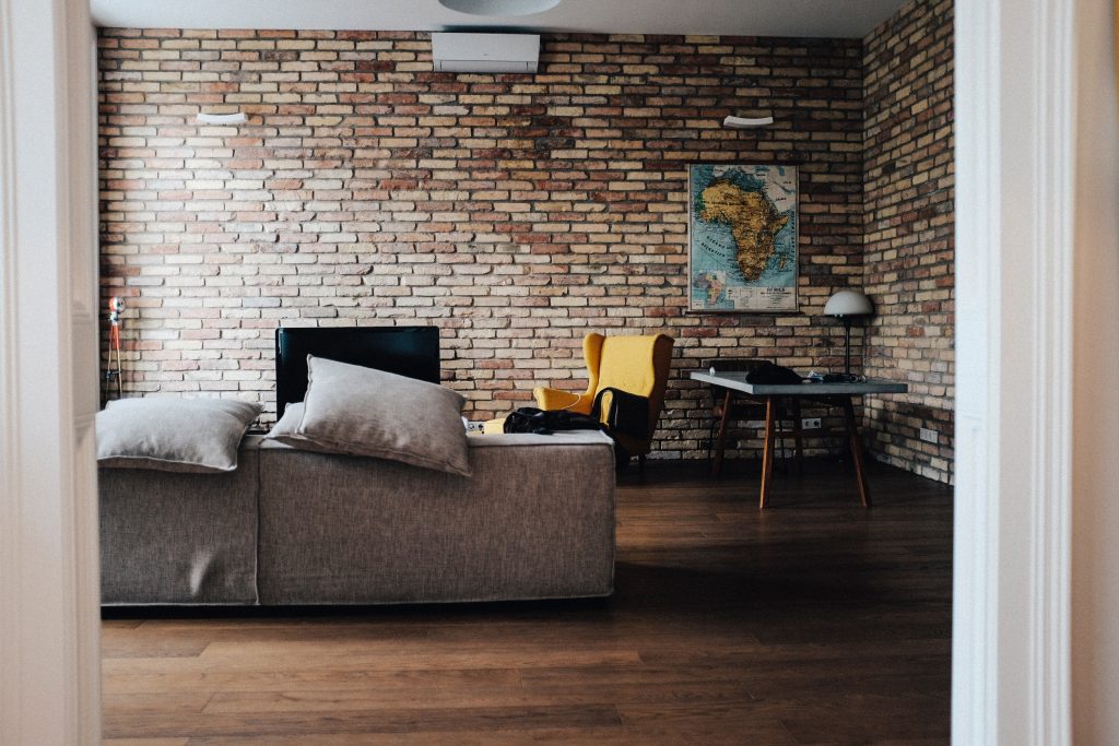 Sala com papel de parede tijolinho mostrando o estilo minimalista barato